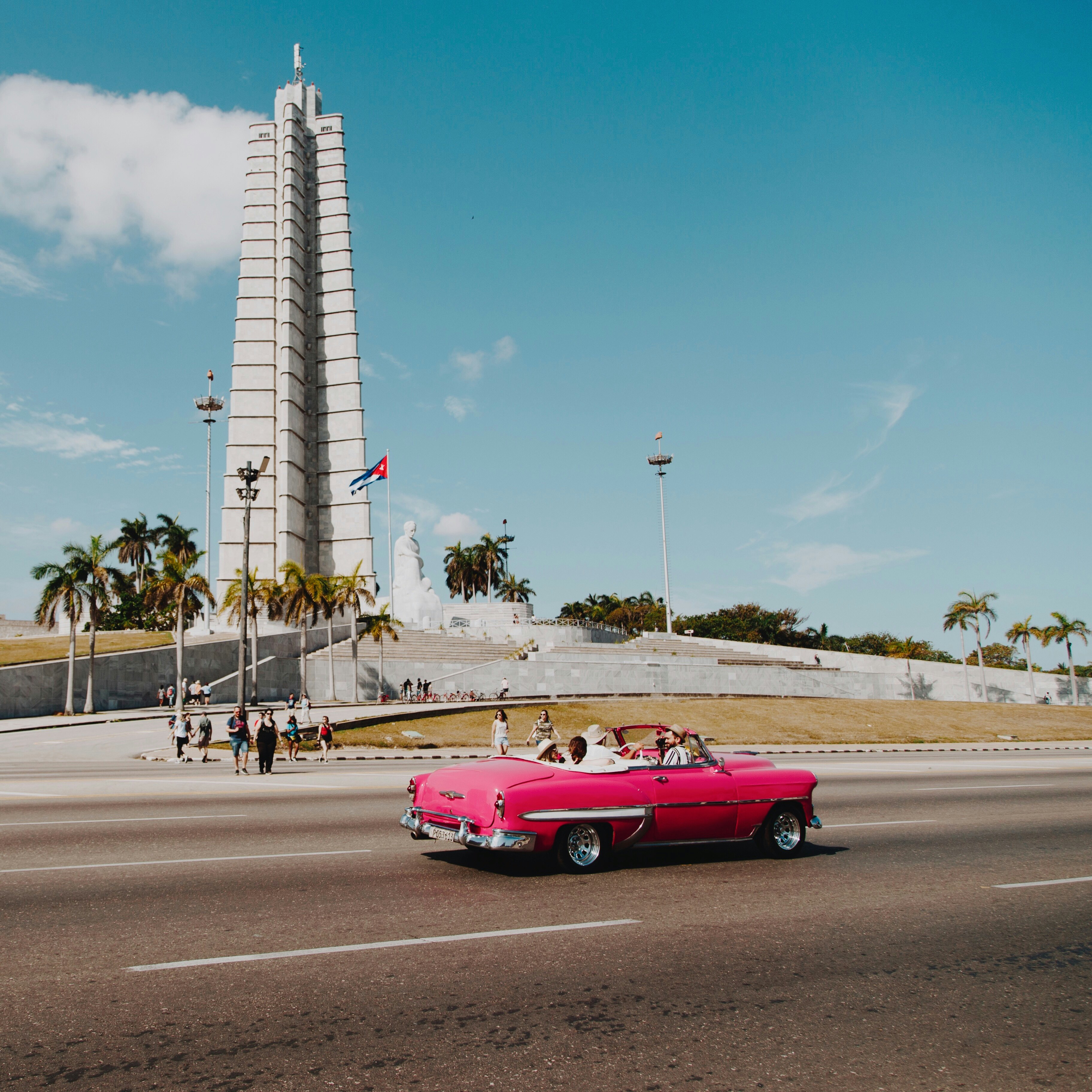 pink coupe passing by monument during daytime